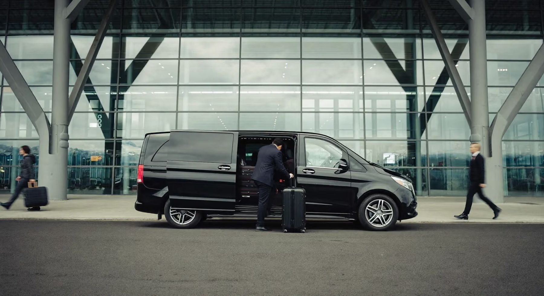 Un chauffeur charge les valises dans un van